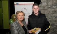 Minister Fitzgerald presents Michael Collins with a raffle prize of a digital camera