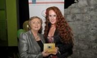 Minister Fitzgerald presents Bridget McDonagh with a raffle prize of a digital camera